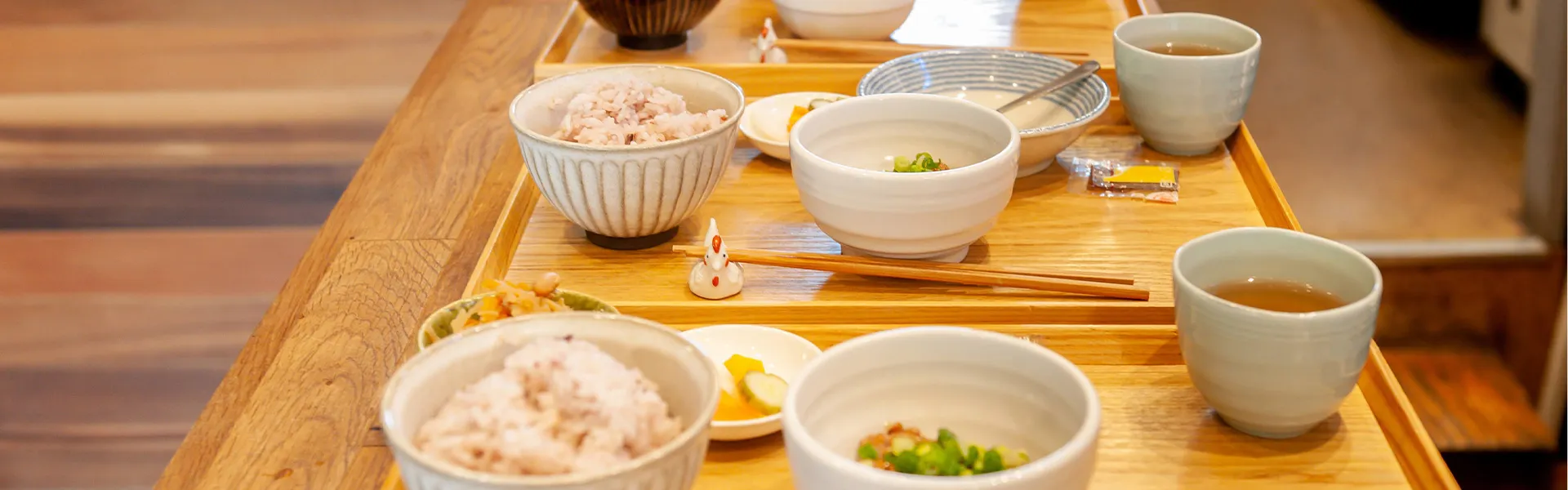 木製テーブルに配置された介護食。ご飯、汁物、副菜が個別の器に盛られている。